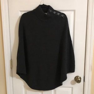 Grey knit poncho imitation black leather trim and four black shoulder buttons.